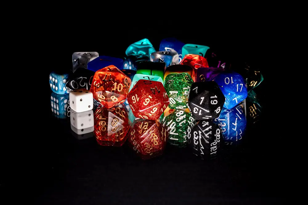 A pile of colourful numbered dice on a black surface